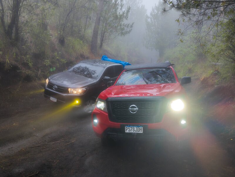 Die Pickup-Trucks kämpfen sich durch den Nebel die Piste zum Startpunkt hinauf