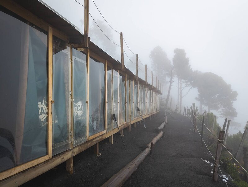 Die Schlafhütten des Basecamps hängen im dichten Nebel am Acatenango
