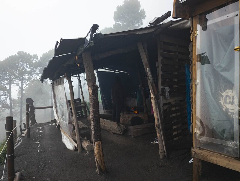 Die einfache Holzküche des Basecamps hängt im dichten Nebel