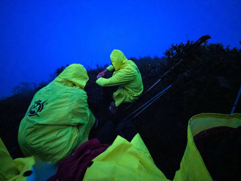 Im Morgengrauen geht es in Regenponchos los zum Gipfelaufstieg